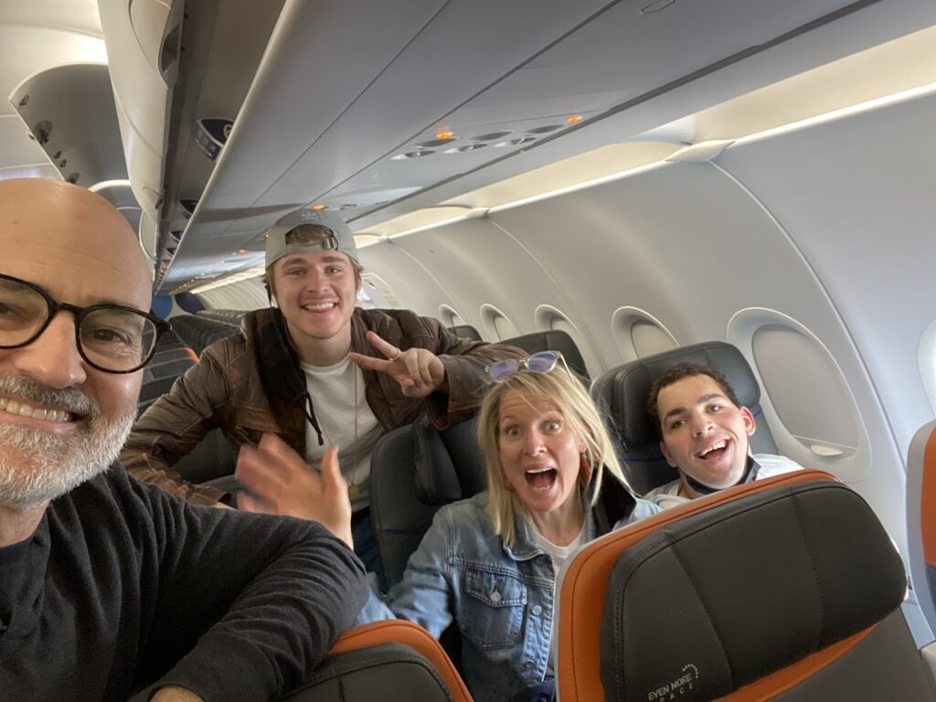 Steve, Kade, Susan and Harold smile in their seats on their plane!  Happy to be flying again finally after COVID for 2 years